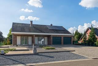 Ruime en uitstekend onderhouden gezinswoning met prachtige tuin en inpandige garage op een perceel van 1.490 m²<br /><br />Deze degelijke en tijdloze woning uit de jaren ’70 werd doorheen de jaren met de grootste zorg onderhouden en gemoderniseerd. Dankzij de combinatie van een EPC-label B, duurzame materialen en een praktische indeling is deze woning volledig instapklaar en vormt ze een ideale thuis voor wie op zoek is naar ruimte, comfort en kwaliteit.<br /><br />Bij het betreden van de woning kom je in een ruime inkomhal die meteen toegang biedt tot verschillende ruimtes. Hier bevinden zich onder andere het bureel, de volledig ingerichte keuken, het gastentoilet en de gezellige leefruimte.<br /><br />De leefruimte ademt warmte en sfeer dankzij de mooie parketvloer en de aanwezige houtkachel. Grote raampartijen zorgen voor een aangename lichtinval en een mooi contact met de tuin. Aansluitend bevindt zich de veranda, een heerlijke plek waar je zowel tijdens de zomermaanden als in de winter volop kan genieten van het uitzicht op de prachtig aangelegde tuin.<br /><br />Op het gelijkvloers bevinden zich daarnaast drie volwaardige slaapkamers en een recent vernieuwde badkamer, uitgerust met een douche, lavabo en praktische ingebouwde kasten.<br /><br />De woning beschikt bovendien over een ruime afgewerkte zolderkamer op de eerste verdieping. Deze polyvalente ruimte is voorzien van een afzonderlijk toilet en biedt dankzij haar oppervlakte tal van mogelijkheden. Zo kan ze perfect dienst doen als hobbyruimte, bureau, speelruimte of mits verdere inrichting zelfs als één of meerdere extra slaapkamers.<br /><br /><strong>Praktische troeven</strong>
<ul>
<li>EPC - label B door oa. zonnepanelen</li>
<li>Volledig onderkelderd (gedeeltelijk kruipkelder) </li>
<li>Inpandige garage met plaats voor 2 wagens</li>
<li>Zijpoort met toegang voor de wagen tot in de tuin</li>
<li>3 slaapkamers op het gelijkvloers + ruime afgewerkte zolderkamer</li>
<li>Douche is rolstoel toegankelijk </li>
<li>Uitstekend onderhouden</li>
</ul>
<br />Interesse?<br />We nemen graag de tijd om je deze woning ter plaatse te laten ontdekken.<br />📞 014 84 83 69<br />✉️ info@sublimmo.be