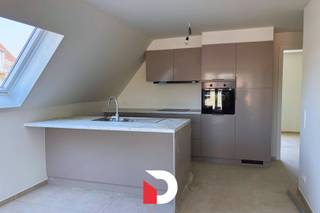 Dit uitstekend afgewerkte nieuwbouwappartement met 1 slaapkamer is rustig gelegen, nabij de belangrijkste invalswegen en op korte afstand van het centrum. Het appartement combineert een aangename woonomgeving met een vlotte bereikbaarheid en hedendaags wooncomfort.<br /><br />De lichtrijke leefruimte sluit aan op de moderne, open ingerichte keuken. Verder beschikt het appartement over één volwaardige slaapkamer, een praktische berging en een stijlvolle badkamer uitgerust met een inloopdouche, lavabomeubel en aansluiting voor een wasmachine. Een mooi terras heeft uit op de gezellige woonwijk.<br /><br />Het appartement is bovendien voorzien van een energiezuinig verwarmingssysteem via een warmtepomp, wat bijdraagt tot lagere energiekosten.<br /><br />Daarnaast is er een private parkeerplaats in de garage voorzien, evenals een gemeenschappelijke fietsenberging. Voor bezoekers is er parkeergelegenheid beschikbaar, inclusief een laadpaal voor elektrische voertuigen.<br /><br />Dit moderne appartement is afgewerkt met kwalitatieve materialen en vormt de ideale woonst voor wie op zoek is naar rust, comfort, energiezuinigheid en een gunstige ligging. Meer dan een bezoek waard!<br /><br />Voorschot gemeenschappelijke kosten: € 20/maand. Er is geen lift aanwezig in het gebouw. EPB in opmaak.