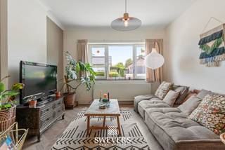 Voor meer info en foto’s, surf naar www.swevers.be – instapklare open bebouwing met 190 m² bewoonbare oppervlakte op een perceel van 5a12ca in de Kerkstraat 15 te Nieuwerkerken. De woning dateert van 1948, werd volledig gerenoveerd in 2012 en kreeg in 2021 een nieuwe keuken en een stijlvolle sfeerhaard. Dankzij de doordachte indeling, grote raampartijen en overvloedige lichtinval geniet u hier van een aangenaam wooncomfort. Op het gelijkvloers vindt u een ruime woonkamer, een gezellige eetkamer, een moderne keuken met veel werk- en bergruimte, een praktische berging en een gastentoilet. De eerste verdieping beschikt over twee ruime slaapkamers, waarvan één met ingebouwde kasten, een badkamer met aansluitende dressing, een apart toilet en een handige wasvoorziening. Via een vaste trap bereikt u de tweede verdieping, waar een hobby ruimte van 36 m² tal van mogelijkheden biedt als master bedroom. Daarnaast is er een kelder van circa 6 m². Buiten geniet u van een zonnige, zuidwestgerichte tuin met fruitbomen, een ruim terras en een overdekt terras. Vooraan is parkeergelegenheid voor drie wagens. Extra troeven zijn de airconditioning, tien zonnepanelen met groenestroomcertificaten en de energiezuinige voorzieningen. De ligging is eveneens een pluspunt, met openbaar vervoer op 100 meter, winkels, scholen en horeca op ongeveer 2 kilometer, een vlotte verbinding naar de snelweg en het Provinciaal Domein Nieuwenhoven op slechts 6 kilometer. Een ideale woning voor wie op zoek is naar ruimte, comfort en een rustige, centrale ligging. Voor meer informatie, bel 012 699 900. Bron bewoonbare oppervlakte: EPC – verslag.