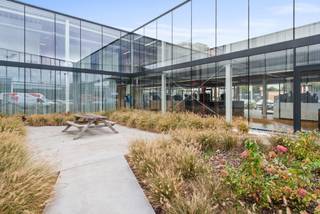 Bent u op zoek naar een nieuw, ruim en multifunctioneel bedrijfspand? Deze indrukwekkende faciliteit biedt een ideale combinatie van een ruime showroom, volledig uitgeruste kantoren en een groot magazijn, perfect voor diverse bedrijfsactiviteiten. Het prachtige gebouw daterend uit 2020 beschikt over grote raampartijen wat voor een uitmuntende uitstraling zorgt. De oppervlakte van de gelijkvloerse ruimte dat perfect kan dienen als showroom/kantoren is 693m². De instapklare en flexibele ruimtes zijn voorzien van vergaderzalen, sanitair, airco, kitchenette, ... Daarnaast beschikt het ook over een magazijn van 800m² (vrije hoogte 7m). Ruime parking aanwezig. <br />Gelegen op een uitstekende locatie naast de A12, biedt dit pand maximale zichtbaarheid en bereikbaarheid.