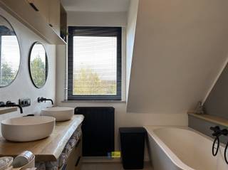 <p><span>Deze woning is centraal gelegen in Kessel en valt meteen op door de aangename, lichtrijke leefruimte (34 m²). Dankzij de grote raampartijen geniet je hier van een overvloed aan natuurlijk licht en een open, uitnodigende sfeer  een ideale plek om tot rust te komen of gezellig samen te zijn. Aansluitend bevindt zich een praktische bureauruimte (13 m²) met ingemaakte kasten, perfect voor thuiswerk of extra opbergruimte. Het volledige gelijkvloers is afgewerkt met kwalitatief maatwerk, wat zorgt voor een stijlvolle en praktische inrichting.</span></p><p><span>De keuken (25 m²) is uitgevoerd in stijlvolle bruin/zwart- en marmertinten en sluit mooi aan op de leefruimte. Van hieruit heb je directe toegang tot de tuin en de terrassen. De woning beschikt over twee terrassen (aangelegd in 2024), zodat je op elk moment van de dag van de zon kan genieten. De zuidgerichte tuin met een oppervlakte van ca. 200 m² (excl. bijgebouw en oprit/voortuin) vormt een aangename buitenruimte. Daarnaast is er een ruime, vrijstaande garage/tuinberging van 28 m².</span></p><p><span>Verder beschikt de woning over een aparte wasruimte (8 m²), een gastentoilet (2 m²) en handige extra bergruimte. In de leefruimte zorgt een pelletkachel voor extra warmte en gezelligheid.</span></p><p><span>Op de eerste verdieping vind je een verzorgde badkamer (9 m²) met dubbele lavabo, toilet en een inloopdouche, afgewerkt in warme houttinten. Daarnaast zijn er momenteel drie kamers: een ruime slaapkamer (15 m²) met ingemaakte kasten, een tweede grote kamer (19 m²) die eenvoudig op te splitsen is in twee volwaardige slaapkamers, en een extra ruimte (4 m²) die perfect kan dienen als dressing of kinderkamer. De nachthal (3 m²) verbindt alles mooi en de verdieping is afgewerkt met laminaat.</span></p><p><span>De zolder (45 m²) strekt zich uit over de volledige woning en biedt tal van mogelijkheden. Deze ruimte kan perfect ingericht worden als extra slaapkamer, waardoor de woning potentieel tot vier slaapkamers biedt.</span></p><p><span>De woning werd in 2020 grondig gerenoveerd en beschikt over een conform keuringsattest voor de elektriciteit. Verwarming gebeurt op gas en met 18 zonnepanelen is er ook aandacht voor energiezuinig wonen.</span></p>