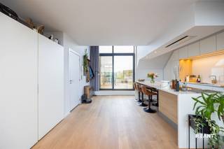 <p><strong>Lichtrijk duplexappartement met mezzanine en uitzonderlijk ruim terras in hartje Sint-Job</strong></p><p> </p><p></p><p></p><p>Dit charmante en stijlvolle duplexappartement combineert hedendaags comfort met een uniek gevoel van ruimte en licht. Gelegen op de tweede verdieping van een verzorgd gebouw met lift, geniet deze eigendom van een bewoonbare oppervlakte van 80 m² en een bijzonder aangename indeling. Dankzij de grote raampartijen die doorlopen tot in de mezzanine baadt het appartement de hele dag in natuurlijk licht, wat zorgt voor een open en luchtige woonbeleving.</p><p> </p><p></p><p>De ruime leefruimte vormt samen met de open keuken het hart van het appartement. Hier komen design en functionaliteit mooi samen. De moderne keuken met kookeiland is afgewerkt met hoogwaardige materialen, witte kasten met warme houten accenten en beschikt over een Quooker-kraan. De geïntegreerde verlichting en de vele opbergmogelijkheden creëren een stijlvolle en praktische werkruimte. De living biedt voldoende plaats voor een gezellige zithoek en wordt extra sfeervol gemaakt door de ingebouwde gashaard met elegante blauwe mozaïektegels. De warme houten vloerafwerking versterkt het uitnodigende karakter van de woonruimte.</p><p> </p><p></p><p>Vanuit de leefruimte heeft u toegang tot twee terrassen. Aan de voorzijde bevindt zich een aangenaam terras van 9 m², terwijl het uitzonderlijk ruime achterterras van 34 m² een heerlijke plek vormt om in alle rust te ontspannen, te genieten van de zon of gasten te ontvangen.</p><p>Op de mezzanine bevindt zich de ruime slaapkamer met open zicht op de leefruimte. Aansluitend vindt u de stijlvolle badkamer, uitgerust met een moderne inloopdouche en een verzorgde afwerking. Daarnaast zorgen de ingemaakte kasten voor extra comfort en praktische bergruimte.</p><p> </p><p></p><p>Dit appartement is uitstekend gelegen in het centrum van Sint-Job-in-'t-Goor. U geniet hier van een rustige en groene woonomgeving, terwijl winkels, horeca, scholen, openbaar vervoer en belangrijke invalswegen zich op korte afstand bevinden. De combinatie van een centrale ligging en een aangename woonomgeving maakt dit een ideale thuisbasis voor zowel alleenstaanden, koppels als professionals die op zoek zijn naar comfort en bereikbaarheid.</p><p> </p><p></p><p>TROEVEN</p><p>+ EPC B – energiezuinig appartement</p><p>+ Duplexindeling met mezzanine en overvloedige lichtinval</p><p>+ Open keuken met kookeiland en Quooker-kraan</p><p>+ Ingebouwde gashaard als sfeervolle blikvanger</p><p>+ Ingemaakte kasten en kwalitatieve afwerking</p><p>+ Verzorgd gebouw met lift</p><p>+ Centrale ligging nabij winkels, horeca en openbaar vervoer</p><p>+ Gemeenschappelijke kosten: €115/maand</p><p>+ Mogelijkheid om een garagebox te huren</p>