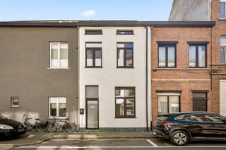 De statige voorgevel van deze hoge woning met dito plafonds, werd voorzien van een mooie plint in blauwe hardsteen en witte sierpleister, die...