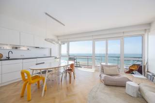 VOLLEDIG VERNIEUWD APPARTEMENT VAN 80 M² MET SLAAPKAMER, SLAAPHOEK EN ZEEZICHT<br />Dit volledig vernieuwde appartement van 80 m² werd met veel aandacht voor afwerking ingericht en is volledig instapklaar. Dankzij de doordachte indeling, de kwalitatieve materialen en de twee terrassen biedt het een bijzonder aangenaam wooncomfort.<br />De inkomhal geeft toegang tot de lichtrijke woonkamer met een luxueus ingerichte open keuken. Vanuit de woonkamer heeft u toegang tot het terras aan de voorzijde, waar u geniet van een prachtig zeezicht. De grote raampartijen zorgen voor een aangename lichtinval.<br />Verder beschikt het appartement over een zeer ruime berging, een afzonderlijk toilet, een ruime slaapkamer en een aparte slaaphoek. De slaapkamer geeft uit op een ruim, zonnig terras met open zicht op de Wellingtonrenbaan. De badkamer is uitgerust met een inloopdouche en een dubbele lavabo.<br />Het visgraatparket en de hoogwaardige afwerking geven het appartement een eigentijdse en stijlvolle uitstraling.<br />Een privatieve kelder en een gemeenschappelijke fietsenberging zorgen voor extra comfort.
<ul>
	<li>Oppervlakte: 80 m²</li>
	<li>Volledig vernieuwd en instapklaar</li>
	<li>Luxueuze afwerking met visgraatparket</li>
	<li>Terras met zeezicht en zonnig terras achteraan</li>
	<li>Mogelijkheid tot huren van autostandplaats</li>
	<li>Individuele kelder en gemeenschappelijke fietsenberging</li>
	<li>EPC: 240 kWh/m²</li>
</ul>