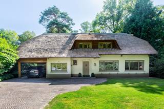 Charmante rietgedekte villa in bosrijke omgeving<br /><br />Deze villa combineert groen, rust en een vlotte bereikbaarheid. Je woont hier midden in de natuur en toch vlak bij de dorpskernen van Schilde en ’s-Gravenwezel, met alle voorzieningen en gezellige horeca binnen handbereik. Ook natuurliefhebbers komen aan hun trekken dankzij de vele wandel- en fietspaden in de buurt.<br /><br />De woning verwelkomt je met een charmante inkomhal en gastentoilet. De ruime leefruimte baadt in licht en biedt een prachtig uitzicht op de tuin. Parketvloeren en een open haard zorgen voor een warme, huiselijke sfeer. Aansluitend vind je de bibliotheek en het kantoor, ideaal om rustig van thuis uit te werken. De keuken is uitgerust met hoogwaardige toestellen en een stijlvol fornuis, terwijl de ontbijthoek uitkijkt op het groen. Extra bergruimte is voorzien in de wasberging en kelder.<br /><br />Boven bevindt zich een royale mastersuite met dressing en badkamer. Daarnaast zijn er drie slaapkamers, waarvan één met ensuite, en een aparte douchekamer. De tuin is onderhoudsvriendelijk aangelegd met volwassen bomen en struiken, waardoor je hier volop geniet van privacy en rust. Het ruime terras sluit mooi aan op de leefruimte en keuken, perfect voor gezellige momenten. Tot slot beschik je over een carport, ruime oprit en tuinberging.<br /><br />Contacteer ons vandaag nog voor een bezoek aan deze unieke woning!