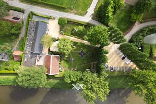Verscholen tussen het groen, met liefst 110 meter oever langs het water, bevindt zich dit rustig gelegen landhuis met bedrijfsgebouw in Lievegem...