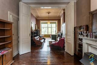 Dit uniek herenhuis is te koop in het centrum van Geraardsbergen.<br /><br />Het huis heeft een ruime inkomhal dat een uitzonderlijk mooie mozaïekvloer heeft, via de inkomhal kan je naar de garage (de inrijpoort is vrij laag) of via de trap kom je in de woonkamer en keuken.<br />Vooraan in het huis is er een ruimte dat kan dienen als bureau, zitplaats enz, deze kan worden afgescheiden van de living door een deur uit meerdere delen.<br />De living en eetplaats hebben grote vensters die uitkijken op de mooie tuin, de ramen beneden zijn in PVC en werden recent vernieuwd.<br />Links achter ligt de keuken waar je toegang hebt tot het terras. Achter de keuken ligt de vernieuwde badkamer. De badkamer is klein, maar heeft een douche, lavabo en toilet.<br /><br />Bijna elke ruimte heeft een marmeren schouw, de meeste vloeren zijn houten plankenvloeren.<br /><br />Op de tussenverdieping van gelijkvloers naar eerste verdiep bevindt zich een toilet.<br /><br />De eerste verdieping heeft 2 grote slaapkamers. De bovenste verdieping heeft 3 slaapkamers. Op beide verdiepingen dienen de ramen vernieuwd te worden. <br /><br />De zolder is ruim en kan nog verder ingericht worden.<br />Het dak werd vernieuwd.<br /><br />De kelder/garage bestaat uit verschillende ruimtes en komt uit op de tuin.<br />De tuin is uiterst aangenaam en heeft een landschildpad als bewoner sinds 2 generaties.<br /><br />Deze woning heeft veel potentieel en kan bv gebruikt worden voor bureau in te maken voor vrij beroep.<br /><br />Interesse in deze parel? Contacteer Isabelle: 0498/10.69.56 of isabelle@cornelis.be