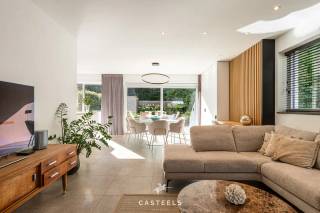 Wonen in een strakke, hedendaagse BEN-woning in een kindvriendelijke en uiterst praktische omgeving in Wondelgem? Deze halfopen bebouwing, gebouwd in 2020, combineert hedendaagse architectuur met hoogwaardige materialen, doordacht maatwerk en een bijzonder aangenaam wooncomfort.<br /><br />Achter de strakke witte gevel, gecombineerd met warme houten accenten aan de gevel en garagepoort, schuilt een instapklare gezinswoning waar functionaliteit en esthetiek mooi in balans zijn.<br /><br />Karaktervolle leefkeuken<br />De open leefkeuken vormt het hart van de woning en is afgewerkt met hoogwaardige materialen. De indrukwekkende marmeren achterwand, een eiland met dubbele spoelbak en de discreet geïntegreerde designverlichting zorgen voor een eigentijdse en sfeervolle uitstraling. Een ideale ruimte om dagelijks te genieten, maar ook om familie en vrienden te ontvangen.<br /><br />Doordachte indeling en hoogwaardig maatwerk<br />Met een bewoonbare oppervlakte van 158 m² biedt de woning een bijzonder comfortabele en praktische indeling.<br />Op de verdieping bevinden zich drie slaapkamers. Eén van de kamers is momenteel ingericht als multifunctionele ruimte, met ingemaakte kasten, een bureau en een geïntegreerd 'verborgen' bed. Dankzij de slimme indeling en hoogwaardige afwerking kan deze ruimte zowel als volwaardige bureauruimte als slaapkamer of logeerkamer worden gebruikt. De aangename natuurlijke lichtinval maakt de kamer bovendien bijzonder geschikt als werk- of slaapruimte.<br /><br />De badkamer is afgewerkt met een eigentijdse inrichting en beschikt over een strakke inloopdouche en een elegant dubbel wastafelmeubel. De leidingen voor de plaatsing van een bad zijn reeds voorzien. Zowel op het gelijkvloers als op de verdieping is er een afzonderlijk gastentoilet.<br /><br />Doorheen de woning werd gekozen voor onderhoudsvriendelijke keramische vloeren in combinatie met vloerverwarming. Marmer- en eikaccenten, aangevuld met talrijke kamerhoge maatkasten, zorgen voor een rustige en kwalitatieve afwerking met een optimale benutting van de beschikbare ruimte.<br /><br />Exclusieve troeven op een rij<br />-Instapklaar<br />-Ingebouwde koffiecorner<br />-Verfijnd maatwerk en hoogwaardige materialen<br />-Vloerverwarming doorheen de woning<br />-Energiezuinige BEN-woning met zonnepanelen (thuisbatterij niet inbegrepen) en laadpaal<br />-Geïntegreerd alarmsysteem <br /><br />Achteraan geniet de woning van een aangenaam aangelegd terras en een onderhoudsvriendelijke tuin, omringd door groen. Het praktische tuinhuis biedt bijkomende bergruimte. De inpandige garage biedt plaats aan een wagen en fietsen en zorgt bovendien voor een rechtstreekse verbinding met de woning.<br /><br />Praktisch en rustig wonen in Wondelgem<br />De woning bevindt zich in Wondelgem, ten noordwesten van Gent, en geniet van een bijzonder praktische ligging. Een rustige, kindvriendelijke woonomgeving wordt hier gecombineerd met een vlotte bereikbaarheid van de belangrijkste invalswegen en het openbaar vervoer.<br /><br />Ook voor gezinnen is de ligging bijzonder interessant. Scholen zoals de Daltonschool (ca. 653 m) en basisschool Klimrek Van Belle (ca. 794 m) bevinden zich op korte wandel- of fietsafstand.<br /><br />Voor de dagelijkse voorzieningen hoeft u bovendien niet ver te gaan: een apotheek, huisarts, park, speeltuin en supermarkten zoals Colruyt en Carrefour Express bevinden zich allemaal binnen een straal van ongeveer 1 kilometer. Een uitzonderlijke, energiezuinige gezinswoning met hoogwaardige afwerking, veel maatwerk en een bijzonder praktische ligging in Wondelgem.