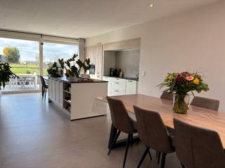 In een rustige doorlopende straat met West-geöriënteerde tuin ....We komen binnen via de hal die toegang geeft tot de grote leefruimte met open...