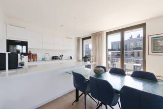 <p>Op de zevende verdieping van deze moderne residentie aan het Kattendijkdok ligt dit prachtig afgewerkt appartement met een uitzonderlijk panoramisch zicht over de stad Antwerpen, het MAS, het Havenhuis en het Kattendijkdok. Een absolute troef voor wie wil wonen in het hart van het bruisende Eilandje én op wandelafstand van de Schelde, de historische binnenstad en tal van gezellige horecazaken.</p>
<p>De open woonkamer, eetruimte en keuken vormen samen een aangename, lichtrijke ruimte die wordt omzoomd door imposante ramen van vloer tot plafond. Waar u ook zit, telkens opent zich een weids uitzicht. Voldoende plaats voor een comfortabele zithoek en een eettafel, met de open keuken als warm middelpunt van de woonst. De volledig geïnstalleerde keuken is stijlvol afgewerkt met marmeren werkbladen en een ruim kookeiland, aangevuld met kwalitatieve ingebouwde toestellen. <br />Het appartement telt twee slaapkamers. De hoofdslaapkamer beschikt over een praktische eigen dressing, terwijl de tweede slaapkamer voldoende flexibiliteit biedt voor kinderen, een thuiskantoor of een logeerkamer. De badkamer is tevens hoogwaardig afgewerkt met marmeren tegels, een ruime inloopdouche en dubbele wastafel — een verzorgd geheel met een luxueuze uitstraling.</p>
<p>Een echte meerwaarde van dit appartement zijn de twee terrassen, georiënteerd op het zuiden en het zuidwesten. Op de terrassen geniet u van een open zicht over de stad, het MAS, het Kattendijkdok en de skyline van de haven. Ideaal om buiten te ontbijten, te lunchen of ‘s avonds na te genieten van de laatste zonnestralen.</p>
<p><strong>Extra troeven</strong></p>
• Hoge berging naast de liften<br />• Dubbele ondergrondse staanplaats met laadpaal van 22 kW te koop aan €45.000<br />• Centrale ligging nabij winkels, horeca en openbaar vervoer<br />• Tijdloze afwerking met natuursteen doorheen het volledige appartement