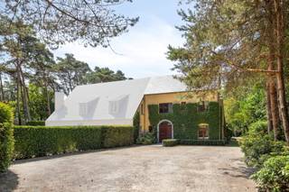 Gelegen in een rustige woonwijk in een landelijke en groene omgeving. De woning Heidedreef 8B is een halfopen bebouwing.<br /><br />INDELING ONDERGRONDS<br />Ruime kelder (33 m²) waarin het CV toestel en de waterontharder geplaatst werden.<br />Verder is er fundering van 1,20m diep.<br /><br />INDELING GELIJKVLOERS<br />Inkomhal / trapzaal met apart toilet.<br />Bureel of slaapkamer.<br />Leefruimte met inbouwcassette op hout. Deze cassette werd mooi omgeven door een schouwmantel in kalksteen en daarrond nog een TV meubel / wandkast in hout.<br />Volledig ingerichte keuken (eik) met aangrenzend aan de ene zijde een berging en veranda aan andere zijde.<br /><br />1E VERDIEPING<br />3 slaapkamers (23 - 16,2 - 9 m²) op parket en waarvan de master met ingerichte dressing.<br />Badkamer met douchekabine, hangtoilet en lavabo.<br />Badkamer met ligbad, douchekabine, hangtoilet en dubbele lavabo.<br /><br />2E VERDIEPING<br />Deze werd (nog) niet ingericht. Wel te bereiken via vaste trap en reeds voorzien van daglicht (ramen).<br /><br />PERCEEL / TUIN<br />Dieper op het perceel werd er nog een vrijstaand gebouw gezet. Hierin vinden we een dubbele garage terug met nog extra tuinberging (41,4 m²). Verder ook nog overdekte carport (18,5 m²) en een atelier / werkplaats (15,6 m²).<br />Ruime voortuin met oprijlaan tot aan de woning. Vooraan afgesloten met draadafsluiting en haag alsook voorzien van automatisch te bedienen poort.<br />Grote achtertuin met helemaal vanachter nog een (zwem) vijver.<br /><br /><br />BIJZONDERHEDEN<br />Verwarming: CV op gas (deels radiatoren, deels convectoren in put). Condenserende ketel Vaillant.<br />Houten ramen met dubbele beglazing en automatisch te bedienen rolluiken.<br />Stedenbouwkundige inlichtingen: in aanvraag.<br />255 m² oppervlakte volgens EPC.<br /><br /><br />POSITIEVE ASPECTEN<br />Heel verzorgde woning.<br />Praktische inrichting.<br />Super mooi perceel met volwassen groenaanleg.