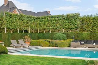Een uitzonderlijke eigendom waar luxe, ruimte, privacy en een adembenemende groene omgeving harmonieus samenkomen.Gelegen in het prachtige Maarkedal, midden in de glooiende Vlaamse Ardennen, ontdekken we deze indrukwekkende klassevilla, tot in de puntjes afgewerkt met hoogwaardige en duurzame materialen (architect Missiaen).De eigendom bevindt zich op een schitterend domein van meer dan één hectare, met een prachtig aangelegde parktuin, ontworpen door Ludo Dierickx. Een oase van rust en groen, waar het zwembad in alle privacy uitnodigt tot heerlijk ontspannen.Ook de ruime oprit en uitgebreide parkeermogelijkheden vormen een absolute troef, en maken deze eigendom bovendien bijzonder geschikt voor de combinatie van wonen en een vrij beroep.INDELINGVia de stijlvolle inkom- en traphal betreden we de woning, waar ruimte, licht en verfijning meteen de toon zetten.De royale, lichtrijke leefruimte, voorzien van een sfeervolle open haard en prachtig parket, geniet van een fenomenaal zicht op het terras en de weelderige parktuin. Grote raampartijen zorgen voor een unieke verbinding tussen binnen en buiten.Verder beschikt het gelijkvloers over een ruime keuken met gezellige ontbijthoek, een praktische bijkeuken en wasplaats, een afzonderlijk bureau en een fitnessruimte.Op de verdieping bevinden zich vijf volwaardige slaapkamers, voorzien van stijlvol maatwerk, en drie badkamers, met alle comfort voor het hele gezin.De woning is bovendien onderkelderd en biedt hierdoor heel wat bijkomende praktische ruimte.EEN UITZONDERLIJKE WOONBELEVINGDeze exclusieve villa combineert een hoogwaardige afwerking met een bijzonder aangenaam wooncomfort, royale leefruimtes en een ongeëvenaard gevoel van rust en privacy.Het indrukwekkende domein, de prachtig aangelegde tuin, het zwembad en de unieke ligging maken van deze eigendom een zeldzame parel in de Vlaamse Ardennen.Een prestigieuze thuis voor wie houdt van klasse, natuur en ruimte, zonder in te boeten aan comfort.Vlaamse Ardennen ten top!