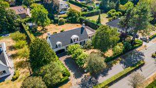 Deze villa geniet van een uitstekende ligging in een doodlopende straat, midden in een groene villawijk van ’s-Gravenwezel. Het dorpscentrum met winkels, horeca, scholen en dagelijkse voorzieningen bevindt zich op korte afstand, terwijl ook Schilde en de omliggende gemeenten vlot bereikbaar zijn. Een aantrekkelijke woonomgeving waar het groene karakter en een uitstekende bereikbaarheid mooi samenkomen.<br /><br /><strong>Indeling</strong><br />Via de oprijlaan met voldoende parkeergelegenheid bereikt u de villa, die toegankelijk is via zowel de centrale inkomhal als de dubbele inpandige garage.<br />De inkomhal met vestiaire en gastentoilet leidt naar de gezellige zithoek met houthaard en aansluitende eetkamer. Daarnaast bevindt zich een polyvalente ruimte, momenteel ingericht als tweede zithoek, maar eveneens geschikt als bureau, lees- of hobbyruimte.<br />De grote raampartijen zorgen voor een overvloed aan natuurlijk licht en bieden vanuit de leefruimtes een prachtig zicht op het terras, de vijver en de fraai aangelegde tuin.<br />Aansluitend aan de eetkamer bevindt zich de uitgeruste keuken met veranda. Dankzij het panoramische zicht over de tuin vormt deze een aangename extra leefruimte. Vanuit de keuken bereikt u tevens de dubbele garage, voorzien van extra bergruimte en aansluitingen voor wasmachine en droogkast.<br /><br /><strong>Verdieping</strong><br />Op de eerste verdieping bevinden zich drie volwaardige slaapkamers, waarvan twee zeer ruim en voorzien van ingemaakte kasten. De master bedroom beschikt over een badkamer (recent gerenoveerd) ensuite met ligbad, douche, lavabo en toilet, evenals een riant privéterras.<br />Daarnaast is er op deze verdieping een afzonderlijk toilet aanwezig.<br />Tot slot beschikt de woning over een praktische opbergzolder, wijnkelder en kruipruimte.<br /><br /><strong>Tuin</strong><br />De fraai aangelegde tuin geniet van een uitstekende zuidoriëntatie en vormt een mooie aanvulling op de leefruimtes. Het terras met vijver creëert een sfeervolle plek om van de tuin te genieten, terwijl achteraan het perceel nog een praktisch tuinhuis aanwezig is.<br /><br /><strong>Bijzonderheden</strong><br />+ Deze architecturale werd in 1976 gebouwd door architect Laporta<br />+ Conforme elektrische installatie<br />+ Gegeerde residentiële ligging<br />+ Zuidgeoriënteerde tuin<br />+ 3 volwaardige slaapkamers<br />+ Dubbele inpandige garage<br />+ Dak recent vernieuwd en geïsoleerd<br />+ Wijnkelder en praktische opbergzolder<br /> 
