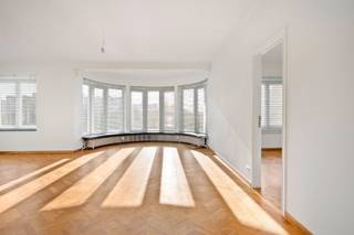 <p>Aan de Camille Huysmanslaan bevindt zich dit bijzonder ruime appartement van 133m². Gelegen op de vierde verdieping van een verzorgd gebouw met lift, geniet de bewoner hier van een weids uitzicht en een uitzonderlijke lichtinval. De grote raampartijen zorgen ervoor dat de zon vrij spel heeft, wat het ruimtegevoel in de leefruimte onmiddellijk versterkt. Het appartement is Zuidwest gericht, wat zorgt voor een lichtinval gedurende de hele dag. Bovendien beschikt de woning over een gunstig EPC B-label, wat garant staat voor een energiezuinig comfort.</p><p>De eyecatcher van dit appartement is ontegensprekelijk de prachtige visgraatparket, die naadloos doorloopt vanuit de woonkamer naar de slaapvertrekken. Deze authentieke vloer geeft de woning een warme, tijdloze uitstraling en vormt een hoogwaardige basis voor elk type interieur. De keuken is modern uitgerust en beschikt over een ruim keukeneiland met opbergruimte langs beide kanten.</p><p>De rust wordt bewaard in de drie zeer ruime slaapkamers, die eveneens zijn afgewerkt met de karaktervolle visgraatparket. Hierdoor ademt het volledige appartement eenzelfde luxueuze sfeer uit. De volledig gerenoveerde badkamer beschikt over een ruime inloopdouche, dubbele wastafel en gesloten kast waar aansluiting voor wasmachine en droogkast voorzien is.</p><p>Tot slot beschikt het appartement over een praktische privatieve berging in de kelder, wat een onmisbare troef is voor extra opslagruimte. Kortom, dit appartement op de vierde verdieping vormt de ideale match voor wie op zoek is naar ruimte, karakter en een uitstekende energetische score op een van de meest gegeerde locaties van de stad.</p><p>Afspraken voor bezichtiging kunnen gemaakt worden door een reactie achter te laten.</p>