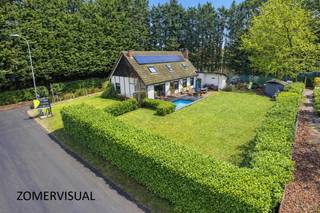 Deze ruime en goed onderhouden villawoning is afgewerkt met hoogwaardige materialen en werd rond 2018 volledig vernieuwd. Ze is gelegen in een rustige en groene wijk en biedt dus veel privacy en comfort.<br /><br />Bij binnenkomst word je verwelkomd in een mooie inkomhal die toegang biedt tot de woonkamer en nachthal. De sfeervolle ruime woonkamer beschikt over een houtkachel, wat bijdraagt aan een warme en gezellige sfeer. Deze woonkamer geniet aangenaam veel lichtinval, terwijl de nodige zonnewering zorgt voor een aangenaam binnenklimaat. De eetplaats in de leefruimte grenst aan de keuken en biedt een prachtig zicht over de tuin.<br />De keuken is volledig uitgerust met kwalitatieve inbouwapparatuur waaronder een gaskookplaat, afzuigkap, combi-oven, combi-stoomoven, vaatwasser en koelkast. <br /><br />De nachthal op het gelijkvloers biedt toegang tot drie slaapkamers, het gastentoilet en de ruime badkamer, welke voorzien is van een inloopdouche en dubbele wastafel in meubel.<br /><br />Via een vaste trap betreed je de verdieping met vide, gezellige lounchehoek en studio/ loft. Deze gezellige ruimte van ca 68 m² kan ingedeeld worden als vierde luxe slaapkamer met ruimte voor een zithoek en is voorzien van een ensuite badkamer met inloopdouche, toilet en wastafel. <br /><br />Naast de woning bevindt zich een aanbouw welke dienst doet als garage met mogelijkheid tot het aansluiten van een toilet, voorzien van aansluiting voor wasmachine, en voldoende stockage ruimte. Deze aanbouw kan eventueel ook omgebouwd worden tot bvb. een extra slaapkamer of bureauruimte. <br /><br />De tuin is volledig aangelegd en voorzien van diverse bomen, struiken en een ingebouwd zwembad, waardoor een groene en rustgevende buitenruimte ontstaat. Het prachtige bijgebouw is opgetrokken met een houtstructuur en kan prima ingericht worden als gezellige buitenhoek (deze is niet zichtbaar op de foto's). <br /><br />* sproei-installatie aanwezig<br />* afgewerkt met degelijke materialen<br />* 100% gezelligheid<br />* gunstig EPC! (B- label)<br />* 11 zonnepanelen<br />* voldoende parkeermogelijkheden <br /><br />Stedenbouwkundige inlichtingen: vergunning uitgereikt (Vg), geen rechterlijke herstelmaatregel of bestuurlijke maatregel opgelegd (Gmo), gelegen in gebieden voor de vestiging van kerninstallaties (zonevreemde woning), geen voorkooprecht ruimtelijke ordening aanwezig (Gvkr), geen verkavelingsvergunning (Gvv)