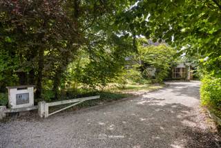 VALIMMAS verkoopt deze riante (± 600m² bebouwd !) en uniek gelegen doktersvilla met praktijkruimte, garage en een grote zuidgeoriënteerde tuin van ± 16 are 71 (eventueel nog uit te breiden tot ± 28 are),...
Deze zeer ruime en solide villa omvat op het gelijkvloers een centrale inkomhal, een toilet, een berging, een bureel, een keuken, een salon en een living met imposante schouw/open haard en uitzicht op het zonneterras en de beboste tuin. De praktijkruimte (voormalige dokterspraktijk) beschikt ook over een aparte toegang met hal en toilet, een wachtkamer of bureel, en de praktijkruimte of bureel met zicht op de tuin. Er is tevens een ruime garage beschikbaar.
De verdieping herbergt een centrale overloop, zes slaapkamers waarvan 1 met dressing, en een badkamer.
De zolderruimte is bereikbaar via een vaste trap, en kan desgewenst nog verder ingericht worden.
Het grootste deel van de woning (± 100m²) is eveneens onderkelderd, met oa. een wijnkelder, de stookplaats, proviandkelders,...
Een deel van de actuele tuin grenst aan de achtergelegen Langevijver(straat), en werd reeds verkaveld in 2 bouwgronden voor open bebouwing (532m² en 570m² , en elk circa 14,60m breed en gemiddeld 38m diep). OPTIONEEL: ook mogelijkheid tot aankoop van het geheel (zijnde de villa op 16a71 + de 2 bouwgronden = ± 27a73) mits de vraagprijs van € 1.299.000.
Deze residentieel gelegen majestueuze villa met grote raampartijen wacht op een zorgvuldige renovatie om opnieuw te schitteren als de parel van weleer.