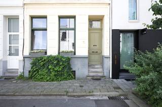 <p>Midden in de gegeerde Harmoniewijk, verscholen tussen statige herenhuizen en gezellige straten, vinden we deze verrassende woning die in 2023 van kop tot teen werd gerenoveerd. Met respect voor haar authentieke uitstraling.<br />Het soort renovatie waar je als koper stiekem heel blij van wordt: zonnepanelen, warmtepompboiler, airco, nieuwe ramen, extra isolatie, conforme elektriciteit, een nieuwe gasketel uit 2025... Kortom, hier zijn de grote werken al achter de rug. En gelukkig bleef de ziel van het huis behouden!</p>
<p>De charmante gevel verraadt al een beetje wat je binnen mag verwachten. Een inkomhal met een speelse tegelvloer, hoge plafonds, sierlijke moulures en een sfeer die je meteen welkom heet. Zo'n huis waar je al na vijf minuten denkt: "Ja, hier zou ik wel kunnen wonen."</p>
<p>De indeling? Die doet gewoon haar eigen ding.</p>
<p>Het gelijkvloers werd ingericht als een zelfstandige studio met keukentje, douchekamer en een ruime leefruimte die vandaag dienst doet als woon- en slaapruimte. Perfect voor een studerende zoon of dochter, een inwonende ouder, een praktijkruimte of gewoon die vriend die telkens "voor een paar dagen" blijft logeren.</p>
<p>Op de eerste verdieping bevinden zich een ruime slaapkamer en een badkamer voorzien van ligbad, dubbele lavabo en toilet.</p>
<p>De tweede verdieping is zonder twijfel de gezelligste plek van het huis. Hier bevindt zich de leefkeuken, badend in natuurlijk licht. Koken, aperitieven, uitgebreid tafelen of nog snel een koffie drinken voor je naar het werk vertrekt: alles gebeurt hier in een warme, huiselijke sfeer.</p>
<p>Helemaal boven wacht nog een multifunctionele ruimte die vandaag dienst doet als zithoek. Maar dit kan net zo goed een slaapkamer, bureau, hobbyruimte of creatieve werkplek zijn.<br />En dan is er nog het dakterras. Niet vergund, wel onweerstaanbaar. Een verborgen stadsplekje waar je geniet van de zon, een goed boek, een barbecue met vrienden of gewoon van het feit dat je in één van de leukste buurten van Antwerpen woont.<br /><br />Deze woning bewijst dat leven niet altijd volgens het klassieke boekje hoeft te verlopen. Hier slaap je beneden en leef je boven. En eerlijk? Dat voelt verrassend logisch.</p>
<p>Troeven die je meteen kan afvinken:<br />- Toplocatie in de Harmoniewijk<br />- Volledig gerenoveerd in 2023<br />- EPC B: 116 kWh/m²<br />- AREI conform<br />- Asbestveilig<br />- Nieuwe ramen met vacuümglas<br />- Dak extra geïsoleerd<br />- Achtergevel geïsoleerd<br />- Zonnepanelen met batterij<br />- Warmtepompboiler<br />- Vaillant condensatieketel (2025)<br />- Airco<br />- Authentieke elementen<br />- Karaktervolle gevel<br />- Droge kelder<br />- Mooi dakterras (niet vergund)<br />- Vraagprijs is richtprijs</p>
