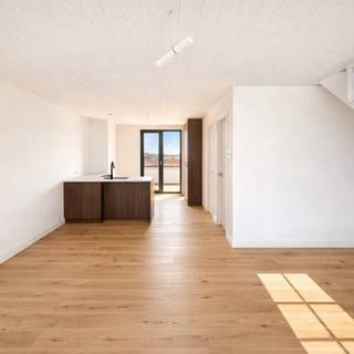 Het trendy dakappartement/duplex heeft een grote leefruimte met berging en bijhorend groot terras dat tevens zuid-gericht is. Op verdiep is een grote slaapkamer met ensuite badkamer die voorzien is van grote inloopdouche & en voldoende plek voor een ruim lavabomeubel. Aparte WC is voorzien. In het appartement ligt vloerverwarming. Mooie open keuken in de living, aansluitend aan terras. <br /><br />Er kan aangekocht worden aan 6% btw. Voor diegene die dus op zoek zijn naar een nieuwbouwappartement, grijp je kans! Weet wel dat je moet voldoen aan volgende voorwaarden:<br />- Eerste eigendom gedurende 5 j, domicilie, enige & eigen woning<br />- het gebouw valt onder sloop & heropbouw, u komt dus in aanmerking (enkel voor de gasketel niet)<br /><br />De werken zijn gebeurd door erkende vakmensen. De appartementen zijn voorzien van een gezamenlijke regenwaterput. Er is gekozen voor aluminium buitenschrijnwerk. De zijgevels zijn met 16cm EPS geïsoleerd. Kortom een appartement waar je de komende decennia 's goed zit. <br /><br />Een gebouw met zeer lage algemene kosten omdat er geen lift aanwezig is...
