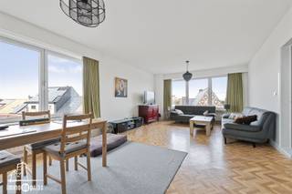 Dit ruime appartement is ideaal gelegen op wandelafstand van het treinstation en tal van buurtwinkels, wat zorgt voor een bijzonder vlotte bereikbaarheid en dagelijks comfort. De centrale ligging wordt verder aangevuld met een grote aparte garage, extra parkeermogelijkheden in de directe omgeving en een aangenaam parkje vlakbij. Het appartement beschikt over twee slaapkamers, een ruime keuken en een lichtrijke leefruimte die uitgeeft op een zuidgericht terras. Het gebouw is voorzien van een lift en biedt comfortabel wonen op een toplocatie waar alles binnen handbereik is. Een aantrekkelijke woonst voor wie ruimte, licht en een uitstekende ligging vlak bij openbaar vervoer en voorzieningen weet te appreciëren.