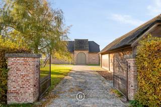Verscholen in een groen en privatief domein van 1,5 ha bevindt zich dit indrukwekkende landhuis met een bewoonbare oppervlakte van maar liefst 605 m2. Een residentie waar ruimte, rust en karakter samenkomen te midden van de uitgestrekte polders van Middelkerke.<br /><br />Vanaf het moment dat u de eigendom bereikt via de oprijlaan wordt duidelijk dat dit geen alledaagse woning is. De ontvangstruimtes ademen karakter en werden ingericht met kwalitatief maatwerk waardoor een warme en stijlvolle leefomgeving ontstaat. De charmante orangerie of bibliotheek biedt een unieke plek om te genieten van de vergezichten over het eigen domein. De landelijke leefkeuken vormt het hart van de woning en sluit naadloos aan op de verschillende leefruimtes. Royale raampartijen brengen het omliggende landschap tot diep in de woning en zorgen voor een voortdurende verbinding met het buitenleven. <br /><br />De verdieping werd ingericht met een royale mastersuite, aanvullende slaapkamers, meerdere badkamers en diverse dressingmogelijkheden. Met een bewoonbare oppervlakte van 605 m2 en een bijzonder flexibele indeling biedt deze eigendom tal van mogelijkheden voor uiteenlopende woonconcepten. De inrichting van een volwaardige kangoeroewoning behoort hier zonder meer tot de mogelijkheden, waardoor verschillende generaties comfortabel kunnen samenleven met behoud van hun privacy.<br /><br />Op het domein bevindt zich bovendien een bijgebouw van 94m2 dat vandaag dienst doet als garage voor meerdere wagens. Voor paardenliefhebbers zijn er drie paardenboxen en een aangelegde piste aanwezig waardoor het geheel perfect aansluit bij een landelijke levensstijl.<br /><br />Dit is een eigendom voor wie op zoek is naar ruimte in haar meest luxueuze vorm.