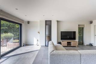 De inkomhal (met vestiaire + toilet) geeft o.a. toegang tot bureel/praktijkruimte en de lichtrijke leefruimte (+ houtvuur) met open keuken (voorzien van alle comfort). Aansluitend aan de keuken nog een bijkeuken/wasplaats en garage (2 wagens).<br /><br />Op de eerste verdieping met nachthal: <br />- Afzonderlijk toilet<br />- Badkamer groot hoekligbad, dubbele wastafel, douche en geïntegreerde stoomcabine<br />- Twee slaapkamers <br />- Derde slaapkamer met eigen terras en dressing<br /><br />Bijkomende zolderverdieping <br /><br />De aangelegd zuidgerichte tuin met tuinhuis/stalling geeft U de nodige privacy en zicht op de weidse velden.<br /><br />Troeven: <br />- Droge kelder en kruipkelder, beiden 60 m2<br />- Energetisch: EPC label A, vloerverwarming met HR-Viessman ketel + zonneboiler, 21 zonnepanelen (piek 5600 Wh), laadpaal voor elektrische wagen<br />- Asbestvrije woning: vernieuwd dak met natuurleien<br />- Domotica-systeem <br />- Regenwaterput<br /><br />Opportuniteit als woning (+ vrij beroep), vakantiewoning, B&B, ….. <br /><br />Ligging: <br />- op 500m van 3 natuurgebieden o.a Raspaillebos <br />- op 900m van Bosberg <br />- 17 min van E429 BXL-Lille. Vlotte verbinding ring BXL en E40 Gent-BXL <br /><br />Interesse in bijkomende info (o.a. plannen, .... ) of bezoekmoment ? Klik dan op deze pagina op de button "Maak een afspraak". Wij contacteren u dan om een afspraak in te plannen. Info 0475 /36 12 52 of pieter@cornelis-goeman.be