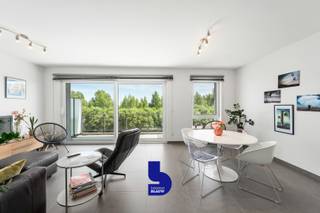 Ontdek dit recent appartement (bouwjaar 2020), ideaal gelegen op de grens van Bredene en Oostende. Gelegen op de tweede verdieping geniet u hier van een prachtig, weids uitzicht op het Vicognebos en de Spuikom. Dankzij de rustige, groene omgeving en de energiezuinige afwerking combineert deze woonst comfort met een uitstekende ligging.<br /><br />Het appartement beschikt over twee volwaardige slaapkamers, een ruime badkamer met zowel een bad als een douche, een apart toilet, een praktische berging en een afzonderlijke wasruimte. De ruime keuken biedt heel wat kastruimte en sluit aan op het zonnige, royale terras waar u in alle rust kunt genieten van het open uitzicht.<br /><br />Ook op vlak van comfort scoort dit appartement uitstekend. Met een EPC-label A (31 kWh/m²) woont u bijzonder energiezuinig en recent appartement. <br /><br />Een autostaanplaats is verplicht aan te kopen voor € 17.500. Daarnaast is er de mogelijkheid om een garagebox aan te kopen voor € 50.000. Bovendien beschikt de residentie over een private bezoekersparking en een fietsenberging.<br /><br />De ligging is een absolute troef. U woont in een rustige woonwijk, omgeven door groen, terwijl Oosteroever, het strand en de zee zich op ongeveer twintig minuten wandelen bevinden. Ook het openbaar vervoer en alle voorzieningen van Oostende zijn vlot bereikbaar.