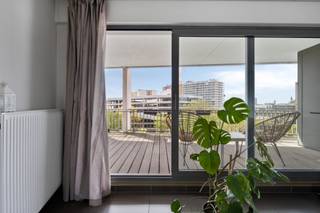 <strong>Hoekappartement met twee slaapkamers en ruim zonneterras.</strong><br /><br />Op de vijfde verdieping bevindt zich dit ruime en lichtrijke appartement met een aangenaam open gevoel.<br /><br />Het appartement beschikt over twee volwaardige slaapkamers, waarvan één slaapkamer is voorzien van een eigen douchekamer en terras met uitzicht op groen en water. In de nachthal bevindt zich bovendien een tweede, volwaardige badkamer.<br /><br />De lichtrijke leefruimte sluit aan op een ruim, zuidgericht terras. Een praktische berging in het appartement zorgt voor extra opbergruimte.<br /><br />Daarnaast beschikt het appartement over een private kelderberging en is er een gemeenschappelijke fietsenberging. Er is tevens de mogelijkheid om een ondergrondse autostaanplaats aan te kopen (€ 30.000).<br /><br />De ligging vormt een extra troef: vlot bereikbaar via de nabijgelegen invalswegen en uitstekend verbonden met de fietsostrade.