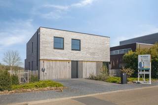 <h2><strong>Landelijk wonen met open vergezichten: stijlvolle villa te Lubbeek</strong></h2><p>–<strong>Interessante aankoopformule onder registratierechten</strong>.-</p><p>In het groene, landelijke Lubbeek word je verwelkomd door deze recente kwadraatvilla (bouwjaar 2024). Een woning die niet alleen uitblinkt in architectuur en afwerking, maar ook in gevoel. Want hier woon je in alle rust met zicht op uitgestrekte velden, en dit zowel vooraan als achteraan. Kom binnen én thuis in licht, luxe en absolute sereniteit. </p><p>De inkomhal verwelkomt je met maatwerk kasten van DM-Line, tevens terug te vinden op meerdere plaatsen binnenshuis, zoals in de inloopdressing of zithoek. Via de glazen deur met stalen frame betreed je de lichtovergoten leefruimte. Met een indrukwekkende plafondhoogte van 3,46 meter en een volledige breedte raampartij baadt de ruimte in natuurlijk daglicht. De leefruimte sluit harmonieus aan op de moderne keuken, hyper uitgerust met kwalitatieve toestellen. Strakke lijnen, hoogwaardige materialen en een subtiele luxe maken van deze ruimte het kloppend hart van je woonst. Slim geïntegreerd vind je een ingemaakte deur naar de berging en wasplaats, waar ook maatwerk werd voorzien.</p><p>Aansluitend op de leefruimte tref je een licht verhoogde, aparte zithoek. Een intieme plek met zicht op het groen vooraan: ideaal wanneer je graag de rust opzoekt om te snuisteren in een goed boek. Op de eerste etage tref je vier volwaardige slaapkamers en badkamers met hotelallures. Eén badkamer beschikt over bad én douche, de tweede over een ruime inloopdouche. Tijdloos design, verfijnde materialen en een afwerking die doet stralen.</p><p>Op beide verdiepingen zorgen parketvloeren voor zachtheid onder de voeten, terwijl vloerverwarming – met individuele collectoren – het comfortniveau verhoogt. De woning werd bovendien gebouwd volgens de hoogste hedendaagse normen met onder andere een geothermische warmtepomp met passieve koeling, ventilatiesysteem D en voor jouw veiligheid: een alarmsysteem van B&B Security. Hier woon je dus niet alleen mooi, maar ook duurzaam. Bovendien zijn alle design verlichtingsarmaturen en maatwerk raamdecoratie inbegrepen in de prijs. Instapklaar betekent dus écht instapklaar.</p><p>Tot slot trekken we naar buiten. De strakke, tijdloze gevel combineert een moderne architectuur met warme materialen. De oprit en inpandige garage met sectionaalpoort maken het praktisch plaatje compleet. En ook je tuin is eersteklas dankzij de groene vergezichten, grote oppervlakte en het aangelegde terras. Een zicht dat nooit verveelt met tevens hemelse wandel- en fietsroutes vlakbij. Tegelijk zijn scholen van Lubbeek tot Leuven vlot bereikbaar. Ook bakker, supermarkt, horeca en andere dagelijkse voorzieningen bevinden zich nabij.</p><p>Graag deze unieke woonst zelf bekijken, en binnenkort zelf in het groene Lubbeek neerstrijken? Geef Jes dan snel een seintje. </p><figure><div></div></figure>