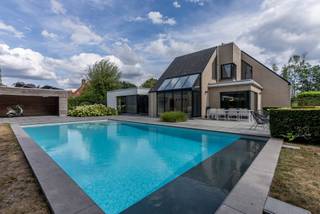 <p>Exclusief wonen in alle rust</p>
<p>Op een ruim en mooi perceel bevindt zich deze stijlvolle, eigentijdse woning waar rust, licht en comfort centraal staan. De lichtrijke leefruimtes en gezellige keuken vormen het hart van de woning, aangevuld met 3 slaapkamers, een dressing, 2 badkamers en een afzonderlijke bureau dewelke ook als extra slaapkamer kan gebruikt worden.</p>
<p>Ook buiten is het genieten: een privézwembad en wellness creëren een luxueuze vakantiesfeer in eigen tuin. Terwijl de dubbele inpandige garage zorgt voor extra comfort.</p>
<p>De woning is hoogwaardig afgewerkt, met alle hedendaags comfort.</p>
<p>Een bijzonder aangename thuis voor wie ruimte, privacy, stijl en comfort weet te waarderen.</p>
<p>Troeven:</p>
<ul>
<li>Zeer rustige omgeving</li>
<li>Ruim perceel</li>
<li>Hoogwaardige afwerking</li>
<li>Dubbele inpandige garage</li>
<li>Welness</li>
<li>Zwembad</li>
<li>Zonnepanelen</li>
<li>Koeling woning</li>
</ul>