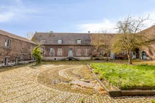 ‘t Hof van Lombeek<br /><br />A farmstead located in the peaceful Sint-Katherina-Lombeek, close to all amenities and major access roads.<br />This property offers numerous possibilities thanks to its impressive size and authentic features.<br /><br />The private driveway with front garden provides access to the enclosed, paved courtyard.<br />From the courtyard, there is a view of the various buildings, which are divided into a single-family home, a guest house, a gatehouse, a barn hall, and a pleasant carport.<br /><br />The land (3,500 m²) is laid out in such a way that it offers several charming outdoor spaces, both around the courtyard, in the front garden, and in the rear garden.<br /><br />Following contact with the municipality, it appears that there are various possibilities for use, including private residence, multi-family housing, and other purposes.<br />For more information or to arrange a viewing, please contact jari.penne@living-stone.be