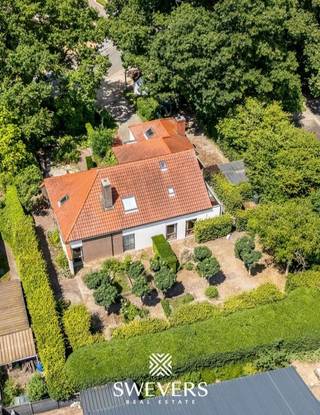 Voor meer info en foto’s, surf naar www.swevers.be – In een rustige, groene buurt van Houthalen-Helchteren vind je deze charmante open bebouwing met volledige privacy op een perceel van 10a 46ca. De woning uit 1974 met vernieuwde bovenverdieping (1988) telt 195m² bewoonbare oppervlakte en biedt ruimte aan vijf slaapkamers, twee badkamers, meerdere terrassen en een mooi aangelegde tuin rondom. De leefruimte van 60 m² met zitkuil en parketvloer sluit naadloos aan op de recente keuken. Daarnaast zijn er drie slaapkamers, een badkamer, een garage en wasplaats op het gelijkvloers. Boven bevinden zich nog twee slaapkamers, een douchekamer, apart toilet en een veelzijdige zolderruimte. Dankzij de niet-dragende muren op de verdieping is herinrichting perfect mogelijk. Extra troeven: videofoon, warmtepompboiler (2016) en uitstekende ligging vlak bij scholen, winkels, horeca en Kasteelbrouwerij Ter Dolen. Voor meer informatie, bel 011 255 155. Bron bewoonbare oppervlakte: EPC – verslag.