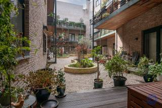 <p><span>Informatie Appartement</span></p><p><span>Op een unieke plek in de stad, aan de charmante Pottenbrug, vind je dit prachtig gerenoveerde appartement waar karakter en comfort mooi samenkomen. Gelegen in een historisch gebouw uit 1905, combineert deze woning authentieke elementen met een hedendaagse, warme uitstraling. Binnenkomen doe je via een ruime inkomhal met vestiaire. De leefruimte is meteen een echte blikvanger. Zon 60 m² groot, met hoge plafonds en veel lichtinval! Aan de ene kant kijk je uit op het Paul van Ostaijenpleintje, aan de andere kant op een rustige, groen aangelegde binnentuin. Aansluitend ligt het westgerichte terras, een fijne plek om te genieten van de avondzon. De open keuken is volledig uitgerust en praktisch ingericht, met kwalitatieve toestellen en voldoende opbergruimte. Ideaal voor wie graag kookt en gasten ontvangt. Het appartement beschikt over twee slaapkamers. De master bedroom is voorzien van een maatkast, terwijl de tweede kamer uitgeeft op het terras. De badkamer is modern afgewerkt met een ruime inloopdouche en maatmeubilair. Daarnaast is er nog een aparte gastentoilet en een handige berging. Alles werd in 2021 grondig vernieuwd, waardoor je hier geniet van hedendaags comfort (EPC B, conforme elektriciteit) in een karaktervol kader. Extra troeven zijn de ruime kelderberging en de mogelijkheid om een auto staanplaats aan te kopen. De ligging is moeilijk te overtreffen... Midden in het historische centrum met winkels, gezellige bars en cultuur op wandelafstand!</span></p><p><span> </span></p><p><span>Indeling</span></p><ul><li><span>Royale inkomhal met ingebouwde, ruime vestiaire.</span></li><li><span>Unieke, lichtrijke leefruimte van maar liefst 60m² én een gevelbreedte van 6m(!), met een prachtig zicht op het pleintje van Paul van Ostayen langs de straatkant, en de prachtig aangelegde binnentuin aan de achterzijde. De leefruimte is voorzien van een hoogwaardige parketvloer en hoge plafonds.</span></li><li><span>Aansluitend aan de leefruimte hebt u toegang tot een west georiënteerd privatief terras van ca. 12m², dewelke uitgeeft op een prachtig aangelegde tuin.</span></li><li><span>De open keuken is volledig uitgerust met een groot inductie kookvuur, design afzuigsysteem, vaatwasser, grote ijskast en een aparte diepvries. Verder is er een ruim werkblad aanwezig en meer dan voldoende opbergruimte.</span></li><li><span>Master bedroom ca. 14m² voorzien van een op maat gemaakte kledingkast.</span></li><li><span>Badkamer voorzien van een grote inloopdouche met handdouche en regenkop, design lavabomeubel met spiegelkast, toilet, op maat gemaakte wandkast voor extra opslag.</span></li><li><span>Slaapkamer ca. 10m² met toegang tot het terras dankzij het schuifraam en met zicht op de binnentuin.</span></li><li><span>Berging ca. 6m² groot met een aansluiting voor een droogkast en wasmachine. </span></li><li><span>Aparte wc met handenwasser.</span></li></ul><p><span> </span></p><p><span>Extra's</span></p><ul><li><span>Het volledige appartement werd grondig gerenoveerd in 2021 waaronder een volledig nieuwe keuken en badkamer!</span></li><li><span>Zeer grote, droge kelderberging (29) inbegrepen in de prijs.</span></li><li><span>Auto staanplaats nr. 5 aan te kopen voor 40.000 euro.</span></li><li><span>Algemene plafondhoogte: ca. 3,00m!</span></li><li><span>Centrale, automatische verluchting in de badkamer, wc en berging.</span></li></ul><p><span> </span></p><p><span>Algemene Informatie</span></p><ul><li><span>Maandelijkse kosten: 240,40 euro/maand (PRIVATIEF waterverbruik van het appartement, onderhoud en verbruik van de gemeenschappelijke delen, lift, syndicus, verzekering, enz.).</span></li><li><span>Individuele meters voor elektriciteit en gas.</span></li><li><span>Collectieve watermeter met tussenmeters.</span></li></ul><p><span> </span></p><ul><li><span>EPC: label B.</span></li><li><span>Elektrische keuring: conform AREI.</span></li><li><span>Asbestattest: asbestveilig.</span></li></ul><p><span> </span></p><p><span>Gebouw</span></p><ul><li><span>In vroegere tijden waren tal van pottenbakkers gevestigd op deze plek. Misbaksels in de letterlijke zin van het woord gooiden ze in de Ruien, vanaf de brug, de Pottenbrug dus. Het gebouw dateert uit 1905 en staat onder Monumentenzorg! Dit betekent dat er aan de buitengevel niets mag veranderen en dat bijvoorbeeld ook geen luifels e.d. mogen worden geïnstalleerd. </span></li><li><span>Het gebouw beschikt over privatieve bergingen, handelsruimten en appartementen op de bovenliggende verdiepingen.</span></li><li><span>Gemeenschappelijke fietsenbergingen.</span></li><li><span>Ruime lift en videofoon aanwezig.</span></li></ul><ul><li><span>Wekelijkse afvalophaling.</span></li></ul><p><span> </span></p><p><span>Ligging</span></p><ul><li><span>Gelegen midden in het historische hart van Antwerpen, met winkels, horeca, cultuur, openbaar vervoer en alle stadsvoorzieningen op wandelafstand.</span></li><li><span>Mobiscore: 9,6/10, een absolute topligging voor wie stedelijk en comfortabel wil wonen.</span></li></ul><p><span> </span></p><p><span>*De informatie in deze prospect is ter informatieve titel: de kandidaat-kopers moeten hun eigen zaak maken van het verkrijgen, controleren en interpreteren van deze informatie.</span></p><p><span> </span></p>