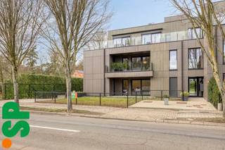 Prachtig gelegen en instapklaar hoekappartement van 94 m² met twee slaapkamers en een privaat tuintje met terras.<br /><br />Dit lichtrijke appartement verwelkomt je via een verzorgde inkomhal met vestiairekast en gastentoilet. Van hieruit kom je in de ruime leefruimte, waar de grote raampartijen zorgen voor een aangename lichtinval en een open, luchtig gevoel. De leefruimte sluit naadloos aan op de volledig uitgeruste keuken (10,2 m²), voorzien van kasten, dampkap, keramisch kookvuur, combi-oven, koelkast, vaatwasser en spoelbak. Vanuit de leefruimte (24,2 m²) heb je directe toegang tot het private tuintje met terras.<br /><br />Via de nachthal bereik je de twee slaapkamers (14,3 m² en 8,9 m²) en de moderne badkamer, uitgerust met een lavabomeubel en comfortabele inloopdouche.<br /><br />Daarnaast beschikt het appartement over een ondergrondse autostaanplaats, inbegrepen in de verkoopprijs, evenals een gemeenschappelijke fietsenstalling en een grote gemeenschappelijke tuin achteraan het gebouw. Alsook is er een lift aanwezig in het gebouw.<br /><br />Op vlak van comfort en energiezuinigheid scoort dit appartement bijzonder goed. De verwarming gebeurt via aardgas met vloerverwarming. Zonnepanelen zijn aanwezig, evenals automatische screens voor zonwering. Met een EPC-label A+ geniet je hier van een uiterst energiezuinige woonst.<br /><br />Kortom, een modern en energiezuinig hoekappartement dat comfort, licht en een aangename buitenruimte perfect combineert.<br /><br />Voor meer informatie of een bezoek ter plaatse, kan u contact opnemen met IMMO SP via 014 59 10 20 of mailen naar jill@immosp.be. Benieuwd naar de waarde van uw eigen woning? Vraag vrijblijvend een gratis verkoopanalyse aan – wij helpen u graag verder!