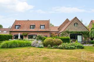 Set on a magnificent, fully fenced landscaped lot of over 5,600 m², this charming property offers approximately 600 m² of living space and features remarkably spacious rooms in a privileged setting.The ground floor opens onto a spacious, double-depth entry hall leading to a 75 m² reception room with a fireplace, which opens widely onto the inner courtyard and garden. The fully equipped kitchen features a utility room and a pantry.An elegant 65 m² master suite completes this level, featuring a bedroom, walk-in closet, and private bathroom.Upstairs, the hallway leads to four beautiful bedrooms, two fully equipped bathrooms, and a study.A converted barn houses a relaxation area with a jacuzzi, pool table, changing room, and shower.Outside, the tree-lined garden, the intimate inner courtyard, the pond, and the heated pool create a rare living environment, sheltered from prying eyes.The property also features two garages with motorized doors, cellars, an attic, and a climate-controlled wine cellar.Features: gas central heating, wood-burning fireplace, double-glazed windows, solar panels, heat pump-heated pool, alarm system, security cameras, video intercom, solid hardwood floors, water cistern, and two garden cottages. Energy Performance Rating: CA unique property combining elegance, comfort, and serenity, in the heart of Néchin.