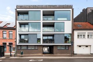 Ruim appartement van 119,5m² met achterliggende garage in hartje Schoten. Het appartement biedt uiterst veel licht door de grote glaspartijen en de gevelbreedte. Inkomhal, woonkamer aan open keuken met kookeiland en ruime berging, toegang naar overdekt terras, badkamer (ruime inloopdouche en dubbele wastafel), apart toilet, 3 slaapkamers en terras over volle breedte. Extra's: achterliggende garage inbegrepen, kelderberging, gemeenschappelijke fietsenberging. Gemeenschappelijke bijdrage 70 Euro per maand.
