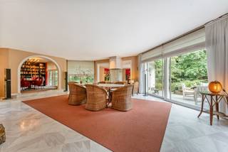 Ruime villa op een uitzonderlijk groot perceel van 4.561 m², residentieel gelegen in de gewilde villawijk ‘Grote Heide’ te Pelt. De woning biedt bijzonder veel ruimte, zowel binnen als buiten, en beschikt over een zeer complete indeling met onder meer vijf slaapkamers, drie badkamers, meerdere leefruimtes, een kantoor en een dubbele inpandige garage.<br /><br />De villa is doorheen de jaren goed zeer goed onderhouden, maar de afwerking en inrichting zijn enigszins gedateerd en bieden ruimte voor modernisering en opfrissing. Dit biedt nieuwe eigenaars de mogelijkheid om de woning naar eigen smaak en hedendaagse woonnormen te renoveren en opnieuw tot een bijzonder ruime en comfortabele gezinsvilla te transformeren.<br /><br />Gelijkvloers<br />Via de ruime inkomhal met gastentoilet heeft u toegang tot de verschillende leefvertrekken. De royale leefruimte is ingedeeld in een afzonderlijke zithoek, een eetkamer en een aparte bibliotheek/TV-kamer. Dankzij de grote raampartijen is er een aangename verbinding met de tuin en geniet de woning van een mooie natuurlijke lichtinval.<br />De ruime ingerichte keuken sluit rechtstreeks aan op de praktische wasplaats/berging.<br />Verder beschikt het gelijkvloers over een afzonderlijke kantoorruimte en een dubbele inpandige garage, geschikt voor het stallen van twee wagens.<br /><br />Eerste verdieping<br />De eerste verdieping omvat een ruime masterbedroom met dressing en een ingerichte ensuite badkamer, uitgerust met een douche, sauna, dubbele wastafel, ligbad en apart toilet.<br />Daarnaast zijn er nog vier bijkomende slaapkamers, allemaal voorzien van inbouwkasten. Eén van deze slaapkamers beschikt over een afzonderlijke douchekamer.<br /><br />De nachthal geeft verder toegang tot een extra badkamer, uitgerust met een douche, ligbad en dubbele wastafel, evenals een afzonderlijk toilet.<br /><br />De royale oppervlakte en praktische indeling maken deze verdieping bijzonder geschikt voor een groot gezin of voor wie nood heeft aan meerdere slaapkamers, hobby- of werkruimtes.<br /><br />Tuin<br />Een van de absolute troeven van deze eigendom is het uitzonderlijk grote perceel van 4.561 m². De ruime tuin biedt volop privacy en mogelijkheden en beschikt over een buitenzwembad en praktische tuinberging.<br />De combinatie van het royale perceel, de bestaande buitenvoorzieningen en de residentiële ligging maakt deze woning bijzonder interessant voor wie op zoek is naar ruimte en potentieel in een groene omgeving.<br /><br />Bijzonderheden<br />•Bouwjaar 1991<br />•Verwarming op stookolie<br />•Alarm aanwezig<br />•Beregeninginstallatie op grondwater<br />•Ideale opportuniteit om de villa naar eigen smaak en hedendaagse normen te renoveren<br />EPC: 270 kWh/m²