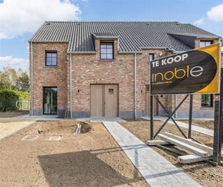 <p>In de rustige en kindvriendelijke Elfenbergstraat in Kuringen stellen wij u graag deze moderne, halfopen nieuwbouwwoning (linkerhelft) voor. De woning bevindt zich op een perceel van 4,64 are en biedt een bewoonbare oppervlakte van 234 m².</p><p>Deze woning is gebouwd volgens de BEN-normen (Bijna-EnergieNeutraal), wat garant staat voor een lage energiefactuur en een duurzame woonkwaliteit. De afwerking gebeurt met hoogwaardige materialen, wat zich vertaalt in een stijlvol interieur met oog voor detail.</p><p><strong>Indeling gelijkvloers</strong><br />Op het gelijkvloers bevindt zich een open leefruimte met veel lichtinval, voorzien van eiken parket en een bureauhoek – ideaal voor wie van thuis uit werkt. De op maat gemaakte keuken is uitgerust met A-merk toestellen: inductiekookplaat met ingebouwde dampkap, vaatwasser, combi-oven, microgolf en inbouwkoelkast. Aansluitend is er een ruime berging/wasplaats. Een gastentoilet is eveneens aanwezig.</p><p><strong>Eerste verdieping</strong><br />Hier bevinden zich twee ruime slaapkamers, een apart toilet en een volledig uitgeruste badkamer met dubbele lavabo, ligbad en een comfortabele inloopdouche.</p><p><strong>Zolderverdieping</strong><br />De ruime zolder biedt een derde slaapkamer, een tweede badkamer (douche en lavabo), een extra toilet én handige bergruimte.<br /><br /><strong>Afwerking en technieken</strong><br />• Laminaatvloeren met V-groef en geluidsdemping in de slaapkamers<br />• Houten trapbekleding in rubberwood, behandeld met Rubio Monocoat<br />• Mitsubishi warmtepomp<br />• Ventilatiesysteem D<br />• Zonnepanelen inbegrepen<br />• Regenwaterput van 7.500 liter<br />• Schüco ramen en deuren<br />• Pré-alarm installatie<br />• Alle nutsvoorzieningen inbegrepen in de prijs</p><p><strong>Prijsopbouw:</strong><br />• Grondaandeel: €175.000 (excl. registratierechten)<br />• Constructie: €443.650 (excl. btw)<br />• Totaalprijs: €618.650 (excl. kosten)<br />📩 Meer weten of een afspraak maken?<br />Vraag gerust het gedetailleerde lastenboek aan of kom deze woning samen met ons ontdekken.<br />Contacteer ons via info@immonoble.be of bel naar +32 472 95 78 44.<br /> </p>