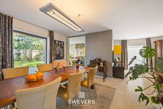 Voor meer info en foto’s, surf naar www.swevers.be – Ruimte, licht en een groene omgeving komen samen in deze instapklare open bebouwing aan de Terlaemenlaan 42 in Heusden-Zolder. De woning uit 2000 biedt 281 m² bewoonbare oppervlakte op een perceel van 9a 28ca en beschikt over EPC-label B. Op het gelijkvloers vind je een ruime inkomhal, apart toilet en een lichtrijke leefruimte van ca. 53 m² met eet- en zithoek. Daarnaast een afzonderlijke bureauruimte naast de woonkamer en één vooraan die kan dienen als vierde slaapkamer. De keuken van ca. 20 m² sluit aan op de wasplaats en berging. De ruime garage biedt extra mogelijkheden, bijvoorbeeld voor een vrij beroep of kangoeroewonen. De eerste verdieping telt drie volwaardige slaapkamers, een badkamer met bad, douche en dubbele lavabo, apart toilet, dressing en berging. Boven de garage bevindt zich een hobbyruimte van ca. 14,5 m² met potentieel als vijfde slaapkamer. Buiten geniet je van een groen perceel met oostelijke en zuidelijke oriëntatie. De woning beschikt bovendien over maatkasten, alarm, rolluiken en zonnewering. De cv-installatie werd in 2023 vernieuwd. De ligging is vlot bereikbaar, met winkels, scholen, openbaar vervoer, natuur en ontspanning in de nabije omgeving. Hasselt bereik je in ca. 15 minuten. Voor meer informatie, bel 011 255 155. Bron bewoonbare oppervlakte: EPC – verslag.