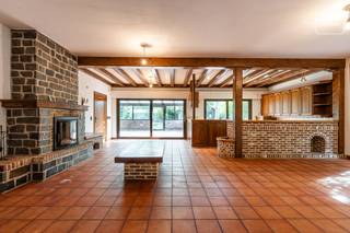Op een bijzonder residentiële locatie, in een uitzonderlijk groene straat gekenmerkt door hoogstammige bomen en verschillende kasteeldomeinen, bevindt zich deze bijzonder ruime bungalow met een uitgesproken modernistisch karakter.<br /><br />De ligging combineert rust en privacy met een uitzonderlijk goede MOBI-score en een bijzonder vlotte bereikbaarheid. Aan de overzijde van de straat bevindt zich een apotheek, terwijl verderop in de straat zowel Colruyt als Delhaize (open tot 20 uur, ook op zondag), een tankstation, kleinhandel en horeca terug te vinden zijn. Meerdere scholen bevinden zich op wandelafstand. De op- en afrit van de R4 ligt op amper 2 minuten rijden en het centrum van Gent is met de fiets in ongeveer 12 minuten bereikbaar.<br /><br />De bungalow onderscheidt zich in de eerste plaats door zijn uitzonderlijke volumes. Niet alleen de leefruimte, maar ook de keuken, slaapkamers en garage zijn bijzonder ruim bemeten. De uitzonderlijk hoge plafonds en de overvloed aan natuurlijk licht versterken het open en ruimtelijke karakter van de woning. Bovendien geniet u vanuit vrijwel de volledige woning van zicht op het omliggende groen.<br /><br />Vanuit zowel de volledige leefruimte als de keuken geniet u van een prachtig zicht op de zuidgerichte tuin. Deze is bijzonder gezellig aangelegd en biedt dankzij het vele groen een hoge mate van privacy. Ook aan de straatzijde wordt de woning door de groene omgeving mooi gebufferd, waardoor het private karakter extra wordt benadrukt.<br /><br />Een absolute troef is de uitzonderlijk grote garage. Door haar afmetingen kan deze zonder overdrijven als een klein atelier worden beschouwd. Ook de garagepoort is royaal gedimensioneerd en biedt toegang aan nagenoeg elke bestelwagen.<br /><br />De woning beschikt momenteel over vloerverwarming en de brede deuropeningen zijn geschikt met het oog op eventuele rolstoeltoegankelijkheid. Ook het EPC-label C vormt voor een woning met dit renovatiepotentieel een interessante uitgangspositie.<br /><br />De bungalow dient gerenoveerd te worden, waarbij onder meer het dak en het interieur aangepakt moeten worden. Precies daarin schuilt echter de bijzondere opportuniteit: dankzij de royale volumes, hoge plafonds, het vele natuurlijke licht en het alomtegenwoordige zicht op groen kan deze woning na renovatie uitgroeien tot een uitzonderlijk modernistisch pareltje met een uniek loftkarakter.<br /><br />Een zeldzame eigendom voor wie op zoek is naar ruimte, licht, privacy en architecturaal potentieel op een bijzonder residentiële locatie vlak bij Gent.