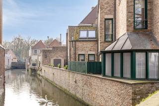 Lichtrijk gelijkvloers appartement met een uitzonderlijke uitstraling gelegen op een toplocatie aan het Wijngaardplein, midden in het historische centrum van Brugge.Hier geniet u van een unieke combinatie van rust, authenticiteit en een prachtig uitzicht op enkele van de mooiste Brugse parels.Via de inkomhal, voorzien van een gastentoilet, betreedt u de ruime woon- en eetkamer. Grote raampartijen zorgen hier voor een overvloed aan natuurlijk licht en creëren een aangename, open sfeer. Aansluitend bevindt zich de volledig uitgeruste keuken.Zowel de leefruimte als de keuken geven uit op het zonnige terras met zicht op de Brugse reien, waar de charme van de stad elke dag opnieuw tot leven komt.Het appartement beschikt over twee volwaardige slaapkamers, waarbij een praktische badkamer zich centraal tussen de slaapkamers bevindt, bereikbaar via de nachtal. Dit appartement biedt niet alleen comfortabel wonen, maar vormt ook een uitzonderlijke opportuniteit voor wie wil genieten van de unieke Brugse sfeer, met een uitzicht dat blijft inspireren.Indeling (146m²):- Inkomhal- Toilet- Woonkamer - Keuken- Badkamer- Slaapkamer 1 - Slaapkamer 2- Terras (65m²)Opmerking: De bijgevoegde AI-visualisaties dienen louter ter inspiratie. Ze houden geen rekening met technische limieten, stedenbouwkundige voorschriften of de feitelijke realisatiemogelijkheden.