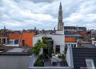 Gelegen aan de charmante Vrijdagsmarkt bevindt zich deze unieke, atypische woning met garage en zuidgericht dakterras, in het hart van Antwerpen.<br /><br />Bij het betreden van de woning komt u binnen in een uitzonderlijk ruime garage met plaats voor twee wagens achter elkaar en voorzien van voldoende bergruimte. Achteraan zijn tevens de aansluitingen voorzien voor een wasruimte.<br /><br />Op de eerste verdieping bevindt zich achteraan de master bedroom, gekenmerkt door een hoog plafond en authentieke balken, met ensuite badkamer, voorzien van een inloopdouche, ligbad, toilet en wastafel. Vanuit de slaapkamer geniet je van een rustgevend uitzicht op de binnenkoer met Japanse esdoorn. Vooraan op deze verdieping bevindt zich een polyvalente ruimte die perfect kan dienen als bureau of extra slaapkamer.<br /><br />De tweede verdieping omvat aan de achterzijde de lichtrijke leefruimte, eveneens georiënteerd naar de binnenkoer. Aan de voorzijde bevindt zich een bijkomende slaapkamer met ensuite douche. Op de nachthal is een apart gastentoilet voorzien.<br /><br />Op de bovenste verdieping bevindt zich een ruime, lichtrijke keuken, uitgerust met alle hedendaagse comfort (SMEG-toestellen). Aansluitend geeft deze verdieping toegang tot het zuidgerichte terras (zonder inkijk), dat een prachtig uitzicht biedt op de Boerentoren, de Onze-Lieve-Vrouwekathedraal en de Vrijdagsmarkt.<br /><br />Verder beschikt de woning over een ruime kelder met hoge plafonds, ideaal als extra bergruimte.<br /><br />Deze eigendom geniet van een uitstekende ligging, vlakbij talrijke winkels, horecagelegenheden, openbaar vervoer en culturele bezienswaardigheden in het centrum van Antwerpen.<br /><br />Grote troeven:<br /><br />- Centraal in historisch centrum<br />- Vernieuwde ramen (niet opgenomen in EPC)<br />- Elektriciteit conform<br />- Geïsoleerde achter- en zijgevel<br />- Digitale meters<br />- Ruime garage met parkeermogelijkheid<br />- Zuidgericht dakterras zonder inkijk<br /><br />Een interessante opportuniteit voor wie op zoek is naar een karaktervolle woning met ruimte en potentieel op een toplocatie.