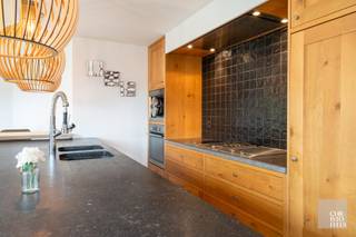 INDELING<br /><br />Bij het betreden van de woning komt u in een ruime inkomhal met vestiaire en gastentoilet. Op het gelijkvloers bevindt zich tevens de masterbedroom, uitgerust met inbouwkasten en een ensuite badkamer, wat bijdraagt aan optimaal wooncomfort. Via een glazen deur bereikt u de eetkamer, die als subtiele scheiding fungeert tussen de gezellige zithoek met pelletkachel en de maatwerkkeuken. De grote raampartijen zorgen voor een aangename lichtinval en geven rechtstreekse toegang tot het ruime terras.<br /><br />Daarnaast beschikt de woning over een praktische kelder met extra bergruimte en aansluitingen voor wasmachine en droogkast.<br /><br />Op de verdieping leidt de nachthal naar slaapkamers twee en drie en de tweede badkamer.<br /><br />De volledig omheinde tuin is voorzien van een aangenaam terras en een tuinhuis. De oprit biedt plaats aan twee wagens.<br /><br /><br />AFWERKING<br /><br />De op maat gemaakte eiken keuken is afgewerkt met een arduin werkblad en uitgerust met kwalitatieve inbouwtoestellen, waaronder een koelkast met vriesvak, aparte diepvriezer, kookplaat met gas-, inductie- en grillfunctie, geïntegreerde dampkap, stoomoven, microgolfoven, dubbele spoelbak en vaatwasser.<br /><br />Badkamer 1 beschikt over een ligbad, inloopdouche en een dubbele wastafel in meubel.<br />Badkamer 2 is ingericht met een inloopdouche, een enkele wastafel in meubel en een toilet.<br /><br />Op het gelijkvloers zijn vloertegels van 90 × 90 cm voorzien, terwijl de verdieping is afgewerkt met laminaat.