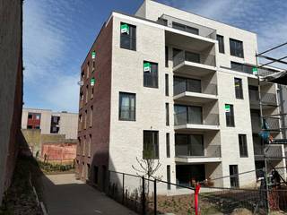 Ben je op zoek naar een nieuw plekje in het bruisende centrum van Leuven? Dit moderne nieuwbouwappartement biedt de perfecte balans tussen rust en de levendige stadsomgeving, en is bovendien direct beschikbaar!<br /><br />Gelegen in het nieuwe, duurzame woonproject Burenberg, biedt deze sfeervolle locatie een eigentijdse woonomgeving midden in de stad met een goede verbinding met de autosnelweg of openbaar vervoer.<br /><br />Het appartement is gelegen op de vijfde verdieping en omvat een inkomhal met apart toilet, twee slaapkamers en een aparte badkamer met inloopdouche en lavabomeubel met spiegel. De lichtrijke leefruimte bevat een volledig uitgeruste open keuken met vaatwasser, spoelbak, inductiekookplaat met vier zones, ingebouwde oven, microgolf, koelkast en aparte diepvriezer. Het ruime terras van 14m² vormt een mooie extra troef. Hier genieten we van veel privacy en een mooi zicht op de binnenstad. Verder is naast de keuken een technische opbergruimte met aansluitingen voor een wasmachine en droogkast. <br />In de ondergrondse verdieping beschikt het appartement bovendien over een privatieve autostaanplaats, een kelderberging en 2 privatieve fietsenstaanplaatsen.<br /><br />Dankzij de bijna energie-neutrale afwerking geniet je hier van een hoog wooncomfort. Het appartement wordt verwarmd door vloerverwarming via een geothermisch net en een ventilatiesysteem type C.<br />Het EPC-certificaat is nog onderweg maar een zeer degelijke A-score is gegarandeerd! Bovendien is het volledige appartement voorzien van zonnewering en gordijnrails.<br /><br />Kortom, een modern, duurzaam en energiezuinig appartement dat onmiddellijk beschikbaar is voor bewoning!<br />De huurprijs bedraagt €1350 per maand, met € 85 provisie per maand voor het onderhoud en verbruik van de gemeenschappelijke delen. Nutsvoorzieningen zijn apart af te sluiten.<br /><br />Lijkt dit ruime, moderne en uitstekend gelegen 2-slaapkamerappartement echt iets voor jou? Wees er dan snel bij en maak zelf een afspraak via onze online agenda onder 'bezoekmoment kiezen. Of neem gerust contact met ons op voor verdere informatie of om een bezichtiging te regelen, via telefoon op 016 23 90 81 (elke weekdag bereikbaar tussen 10u en 13u). Dit is een geweldige kans die u niet wilt missen!