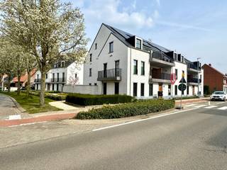 BENIEUWD? VRAAG EEN AFSPRAAK AAN VIA WWW. HILLEWAERE.BE EN KLIK OP DE RODE KNOP 'BEZOEK AANVRAGEN'.<br /><br />Van klasse gesproken! Dit nieuwbouw appartement is gelegen op het gelijkvloers in een mooi complex in de dorpskern van Tielen, nabij winkels en openbaar vervoer. Smaakvol en luxueus afgewerkt! <br /><br />Indeling:<br />Aan de achterzijde bevindt zich de woonkamer die uiterst licht is door de brede raampartij. Hier is voldoende ruimte om een zithoek te creëren en een eettafel te plaatsen. Van hieruit kan je naar het ruime en uiterst gezellige terras (18m²) in het groen. De open keuken met eiland is toch wel de blikvanger! Prachtig werkblad en voorzien van een inductievuur, vaatwasser, combi-oven en koelkast. De smaakvolle verlichting krijg je er als bonus bij. <br /><br />Via een zwart stalen glazen deur kom je tot de hal. Hier bevindt zich de badkamer. Deze is ingericht met een wastafel, inloopdouche en praktische ingemaakte kast. De wasplaats heeft voorziening voor wasmachine en droogkast. De leidingen zijn hier netjes weggewerkt achter een wand. Verder is er nog een apart toilet en 2 slaapkamers met elektrische rolluiken.<br /><br />De huur omvat tevens een ondergrondse parkeerplaats (10) met aansluitend een zeer ruime private kelderberging (8).<br /><br />Bijzonderheden:<br />- Duurzame materialen<br />- Verlichting aanwezig<br />- Zonnepanelen<br />- Vloerverwarming over gans het appartement<br />- Vliegenramen<br />- Lift aanwezig<br />- Servicekosten: 75 €/maand<br />- Beschikbaar vanaf 1 mei