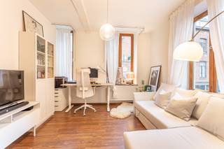 Op zoek naar een aangename en lichtrijke thuis op een absolute toplocatie? Dit charmante hoekappartement van ca. 61 m² bevindt zich in de Sint-Barbarastraat 2, midden in het centrum van Leuven. Dankzij de vele raampartijen geniet het appartement van een bijzonder fijne lichtinval en een warme, huiselijke sfeer. Het appartement beschikt over een gezellige leefruimte met plaats voor zowel een salon als een bureauhoek. Aansluitend vindt u de eetruimte en de geïnstalleerde keuken. Verder zijn er een volwaardige, afzonderlijke slaapkamer, een ruime badkamer met douche, lavabo en toilet, en een praktische aparte berging. De centrale ligging vormt een absolute troef: winkels, horeca, openbaar vervoer, universiteitsgebouwen en alle voorzieningen van de Leuvense binnenstad bevinden zich op wandelafstand. Toch biedt het appartement binnen de nodige rust en privacy. Het appartement wordt onbemeubeld verhuurd en is beschikbaar vanaf 1 augustus 2026. Voor de gemeenschappelijke kosten wordt een vaste bijdrage van €30 per maand aangerekend. Minimumduur contract bedraagt 3 jaar. Wenst u graag een bezoek of extra informatie? Aarzel dan zeker niet contact op te nemen via info@homies.be of 016 15 37 11.