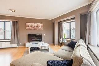 Dit appartement is ideaal gelegen voor wie graag in de nabijheid van het <strong>stadscentrum</strong> vertoeft. De Grote Markt, evenals tal van andere <strong>voorzieningen</strong>, bevinden zich <strong>op</strong> <strong>wandelafstand</strong>.<br /><br />Bij het betreden van het appartement komt u terecht in een <strong>ruime</strong> <strong>inkomhal</strong>. Aan de linkerzijde bevindt zich de <strong>eerste</strong> <strong>slaapkamer</strong>. Wanneer u verder doorloopt bereikt u de <strong>ruime</strong> <strong>woonkamer</strong>. Dankzij de vele raampartijen geniet deze ruimte van <strong>overvloedig</strong> <strong>natuurlijk</strong> <strong>licht</strong>. Aansluitend aan de woonkamer bevindt zich de <strong>keuken</strong>. Deze is eenvoudig ingericht, maar beschikt over alle <strong>hedendaagse</strong> <strong>voorzieningen</strong>, met uitzondering van een vaatwasser. Hiervoor is evenwel een aansluiting voorzien, zodat deze desgewenst kan worden geïnstalleerd. Aan de andere zijde van de inkomhal bevindt zich de <strong>tweede</strong> en tevens <strong>grootste</strong> <strong>slaapkamer</strong>. Recht tegenover deze kamer treft u de <strong>badkamer</strong> aan, uitgerust met een <strong>douche</strong> en <strong>aansluiting</strong> voor een <strong>wasmachine</strong>.<br /><br />Het appartement is gelegen op de <strong>vierde</strong> <strong>verdieping</strong> en is bereikbaar via een <strong>lift</strong>. De <strong>verwarming</strong> gebeurt op <strong>aardgas</strong> en alle nutsmeters zijn digitaal. Gezien de vele troeven kan dit appartement zowel gebruikt worden als hoofdverblijfplaats, tweede verblijf of als <strong>investering</strong>.