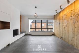 Voor meer info en foto’s, surf naar www.swevers.be – In het hart van Leopoldsburg vindt u deze charmante en instapklare rijwoning met centrale ligging in de Tramstraat. inkels, scholen, restaurants en openbaar vervoer liggen op wandelafstand, wat deze woning ideaal maakt voor eigen bewoning én als investering. De woning werd oorspronkelijk gebouwd in 1965, maar onderging de voorbije jaren belangrijke renovaties. Zo werden de voorgevelramen vernieuwd in 2012 en volgde in 2021 een totaalrenovatie van onder meer keuken, badkamer, elektriciteit, verwarming, dak en achtergevelramen. Met een bewoonbare oppervlakte van 152 m² is er verrassend veel ruimte. Op de eerste verdieping bevindt zich een gezellige leefruimte van 18,44 m², aansluitend op een ruime en moderne keuken van 17,13 m². Van hieruit heeft u rechtstreeks contact met het overdekte terras van 13 m². De glaspartij tussen keuken en terras kan volledig opengeschoven worden, waardoor binnen en buiten mooi in elkaar overlopen. Op de tweede verdieping zijn er twee slaapkamers, waaronder één met dressing. De tweede kamer van 13,92 m² is geschikt als slaapkamer, bureau of hobbyruimte. De vernieuwde badkamer is praktisch en comfortabel ingericht. Achteraan ligt een onderhoudsvriendelijke tuin van 96,29 m². Verder beschikt de woning over een inpandige garage van 20,16 m² met sectionale poort, plus praktische berg- en wasruimte op het gelijkvloers. Dankzij EPC-label B, conforme elektriciteit en de huidige verhuur via een sociaal verhuurkantoor aan €700 per maand is dit ook een interessante, zorgeloze investering. Voor meer informatie, bel 011 255 155. Bron bewoonbare oppervlakte: EPC – verslag.