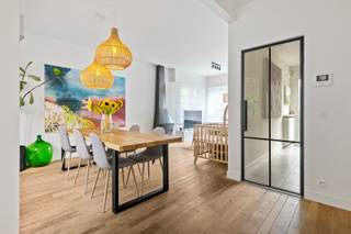 Een instapklare halfopen woning waar licht, hedendaags wooncomfort en een groene tuin mooi samenkomen. De woning werd recent en met zorg gerenoveerd, met aandacht voor duurzame, kwaliteitsvolle materialen en een verzorgde afwerking. Vooral de open leefruimtes, de lichtrijke keuken en de bijzonder private westgerichte tuin geven de woning een warme, rustige woonbeleving.<br /><br />De Laarsebaan biedt daarbij een interessante combinatie van bereikbaarheid en dagelijks comfort: scholen, winkels en openbaar vervoer bevinden zich in de onmiddellijke omgeving, met onder meer een basisschool en een halte van De Lijn in de straat. Ook de groene en recreatieve mogelijkheden van Merksem, waaronder het Fort van Merksem en verschillende parken en speelzones, liggen vlot binnen bereik. Tegelijk is er een goede aansluiting richting Antwerpen en de omliggende gemeenten.<br /><br /><strong>Indeling</strong><br />De ruime oprit biedt voldoende parkeergelegenheid en leidt naar de praktische garage.<br /><br />Via de inkomhal met afzonderlijk gastentoilet bereikt u het leefgedeelte.<br />Vooraan bevindt zich de woonkamer, die op een natuurlijke manier overloopt in de centraal gelegen eetruimte. Van hieruit opent de woning zich verder naar de tuinzijde, waar de keuken zich over de volledige breedte uitstrekt.<br />Net daar komt één van de sterkste eigenschappen van de woning mooi tot uiting: grote raampartijen en bijkomend licht van bovenaf maken van de keuken een bijzonder heldere leefruimte, met het groen voortdurend in het zicht.<br />De keuken staat rechtstreeks in verbinding met de garage én met het gezellige terras, waardoor binnen en buiten op een vanzelfsprekende manier in elkaar overvloeien.<br /><br />Achteraan wacht een verrassend groene en beschutte tuin. De <strong>westelijke oriëntatie</strong> laat u hier volop genieten van de namiddag- en avondzon, terwijl de volwassen beplanting voor bijzonder veel privacy zorgt.<br /><br /><strong>Eerste verdieping</strong><br />Op de eerste verdieping bevinden zich twee volwaardige slaapkamers.<br />De badkamer aan de tuinzijde is voorzien van een ligbad en dubbele lavabo en geniet van een aangenaam groen uitzicht. Daarnaast is er een tweede badkamer met douche in bad, toilet en lavabo. Op de overloop werd bovendien een praktische nis voorzien.<br /><br /><strong>Zolder</strong><br />De volledig ingerichte zolderverdieping biedt nog een royale bijkomende kamer en leent zich uitstekend als master bedroom, maar kan evengoed dienstdoen als bureau-, hobby- of logeerruimte.<br />Tot slot beschikt de woning over een kelder en kruipruimte.