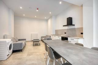 Achter deze charmante gevel bevindt zich een volledig gerenoveerd studentenhuis met 4 studio’s en 3 kamers met eigen badkamer. Het pand wordt instapklaar verkocht en is volledig verhuurd voor het komende academiejaar, waardoor het een interessante opportuniteit vormt voor wie wil investeren in studentenvastgoed. Dankzij de centrale ligging tussen Thomas More en het station genieten studenten van een vlotte bereikbaarheid, terwijl de groene en rustige omgeving zorgt voor een aangename woonomgeving. Zowel de campus als het openbaar vervoer bevinden zich vlakbij. Alle studio’s en kamers zijn bemeubeld met een bed, bureau en kast. Daarnaast beschikken ze over een kitchenette of een vast meubel met microgolfoven en koelkast. Op het gelijkvloers bevinden zich een praktische inpandige fietsenstalling en een gemeenschappelijke leefruimte en keuken met buitenruimte, ideaal om elkaar te ontmoeten en te ontspannen. Het pand genereert een maandelijkse nettohuurstroom van € 4.700, met een indicatief rendement van 4,8%. Ook de brandweercontrole, de uitbatingsvergunning en het Topkotlabel worden voorzien. Het EPB-verslag is momenteel in opmaak. Een volledig gerenoveerd en verhuurd studentenhuis dat comfort, een strategische ligging en een aantrekkelijk investeringspotentieel combineert. Contacteer ons vrijblijvend voor meer info of een bezoek! 