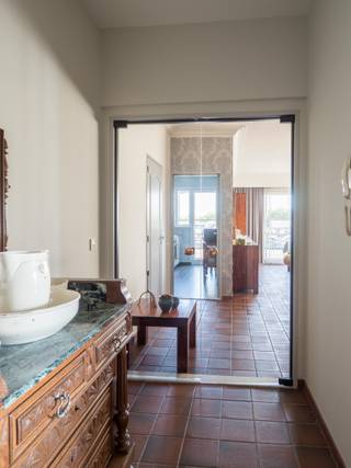 <p>Dit appartement bevindt zich op de <strong>tweede verdieping</strong> van een verzorgd en goed onderhouden gebouw, dat bovendien is uitgerust met een <strong>lift</strong>. Het ligt in de gezellige en kindvriendelijke <strong>Neerlandwijk</strong>, een wijk die bekendstaat om haar rustige sfeer en tegelijk zeer centrale ligging. Dankzij de nabijheid van de A12, E19 en de Ring van Antwerpen zijn de belangrijkste invalswegen vlot bereikbaar. Ook het openbaar vervoer is uitstekend geregeld: een bushalte bevindt zich letterlijk om de hoek. Voor de dagelijkse boodschappen zijn winkels, een apotheek en een bakker op wandelafstand aanwezig, en op het einde van de straat vind je het groene Neerlandpark, ideaal voor een ontspannende wandeling of een sportieve activiteit.</p><p><br /></p><p>Bij het binnenkomen van het ruime appartement kom je in een inkomhal met <strong>ingemaakte vestiairekasten</strong> en een apart gastentoilet. De royale woonkamer aan de voorzijde baadt in het licht dankzij de <strong>grote raampartijen</strong> en biedt voldoende plaats voor een eet- en zithoek. De aparte keuken is praktisch ingericht en uitgerust met alle nodige toestellen: een oven, gaskookplaat, dampkap, dubbele spoelbak en koelkast.</p><p>Aan de achterzijde bevinden zich <strong>drie volwaardige slaapkamers</strong>, die zowel als slaap-, werk- of hobbykamer kunnen dienen. De badkamer is voorzien van een ligbad, aparte douche en wastafel.</p><ul><li>Zeer energiezuinig = EPC A</li><li>Elektriciteit is conform</li><li>Ruim appartement met 3 slaapkamers</li><li>Individuele verwarming</li><li>Rustig gelegen met veel parkeermogelijkheden</li></ul><p>Kortom: een zeer ruim en functioneel appartement op een <strong>rustige en centrale locatie</strong>, perfect geschikt voor wie op zoek is naar een aangename woonomgeving met alle faciliteiten in de buurt.</p>